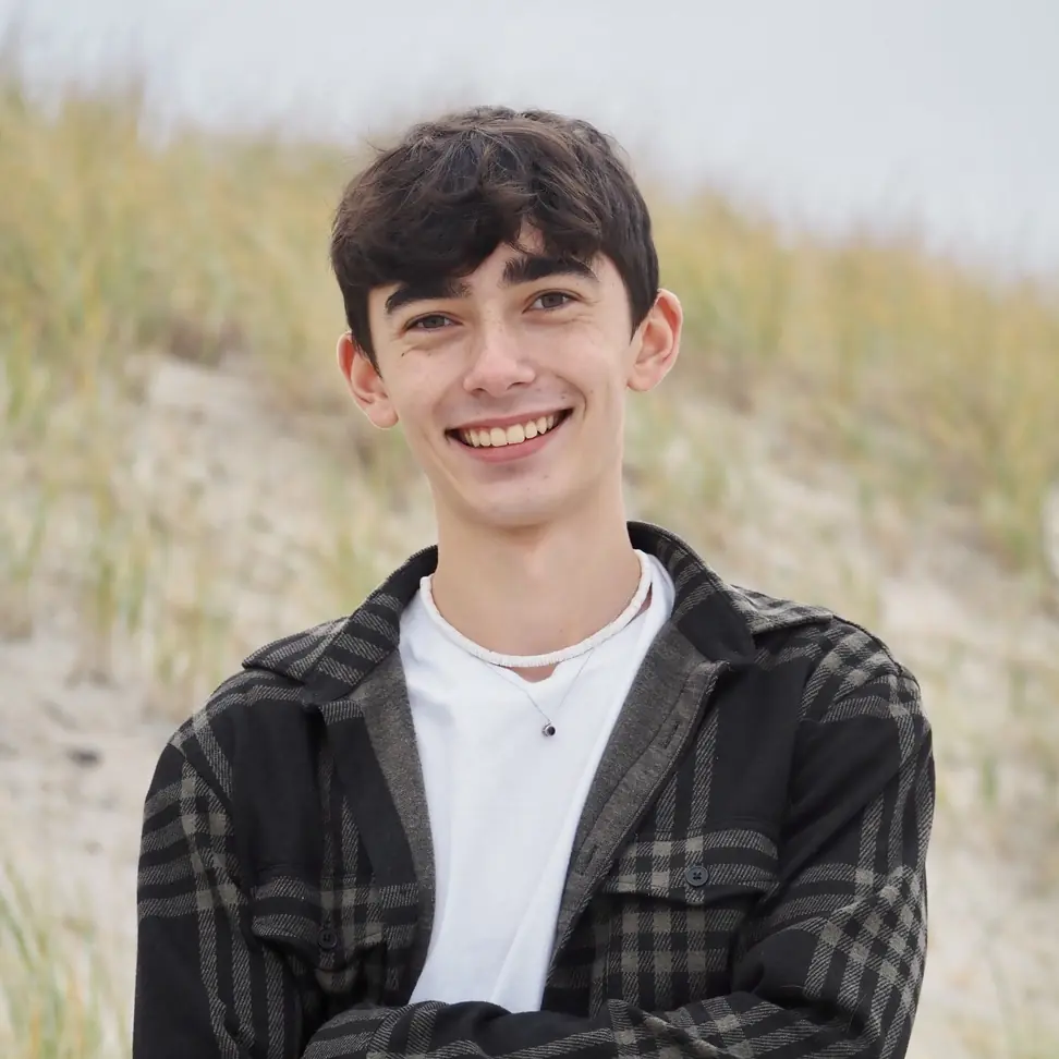 Jacob standing on a beach smiling into the camera